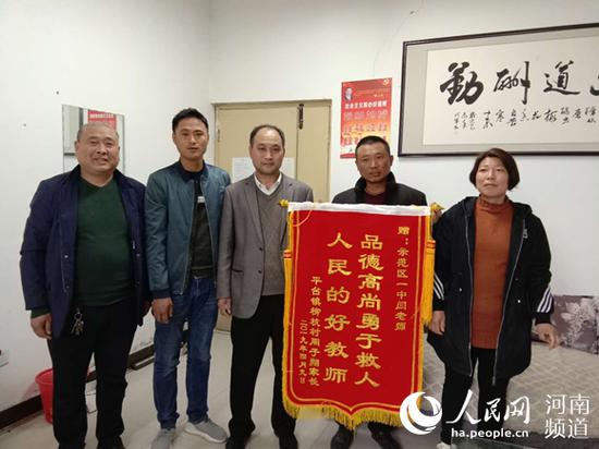 周子翔家長為閆世剛（中）送上錦旗&nbsp; 賀士軍攝