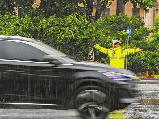 8月12日，郑州市执勤民辅警坚守路口，有序疏导过往车辆。 本报全媒体记者 宋亚猛 摄