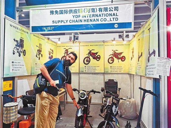 广交会上，东欧客商询问电动车的续航性能。 郭俏丽 摄