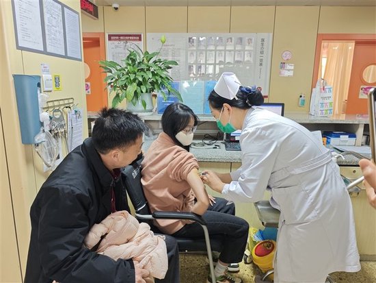 父亲杨振亚陪着女儿杨可欣打动员针。受访者供图