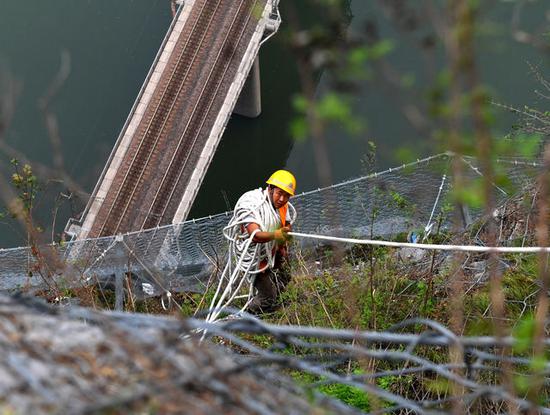 8月9日，抢险人员从侯月铁路柏枝隧道上方山顶垂降，准备进行碎石作业。