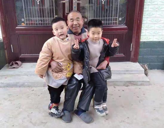 今年春节期间,父亲与我家二宝(左)及侄子(右)在家门口合影 作者提供