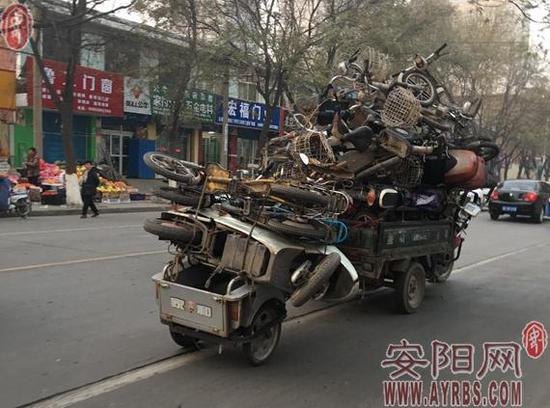 安阳街头这俩三轮车好任性 车上堆满破旧自行