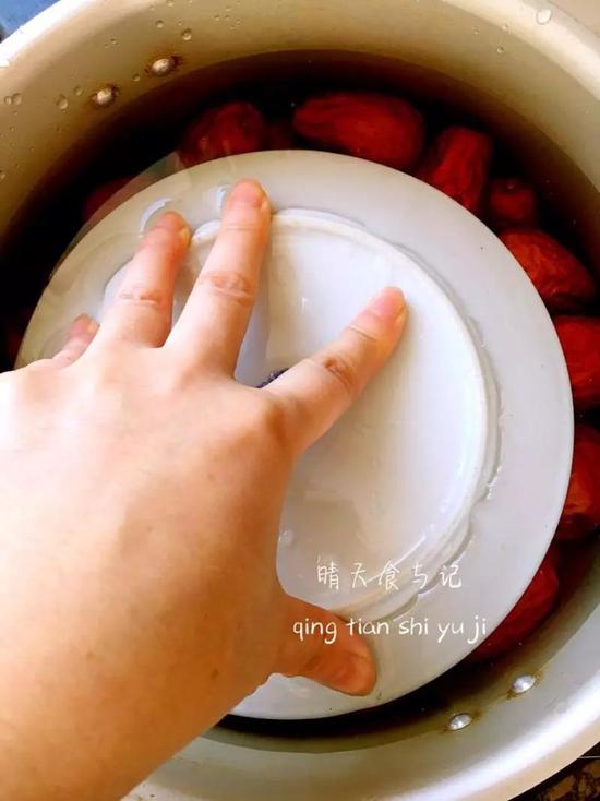 2。将枣放到高压锅中,倒入刚好没过枣的水(我放盘子的意思是因为枣遇水会浮起,用盘子压一下,可以看到水量的多少。煮的时候是不放盘子的。)