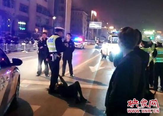 郑州一女子紧抱交警腿 助涉嫌酒驾男司机逃跑 视频截图