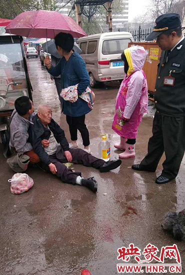 郑州快递小哥撞倒八旬老人 女孩雨中为老人撑