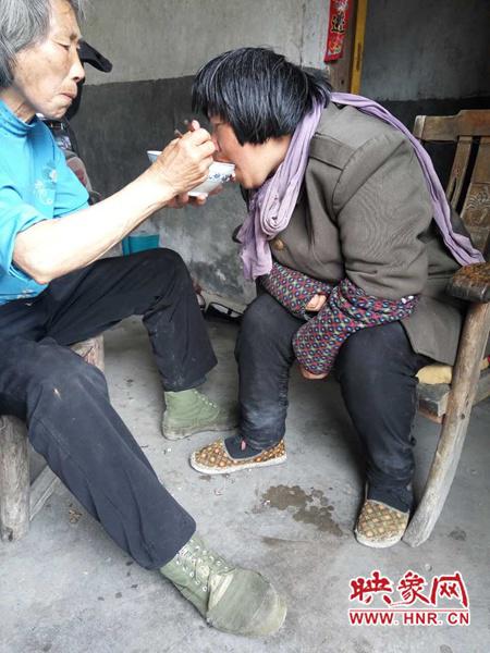 奶奶在喂脑瘫的姑姑吃饭