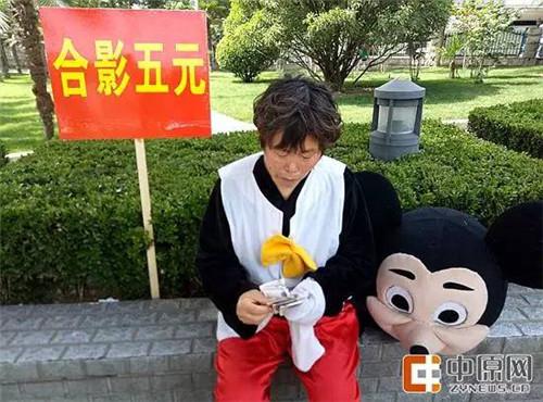 合影5元,扮演米奇的赵阿姨数着手里的钱。(云悉供图)