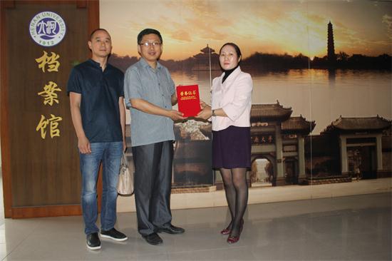 档案馆馆长齐彦波（中）代表学校向王二霞夫妇颁发捐赠证书