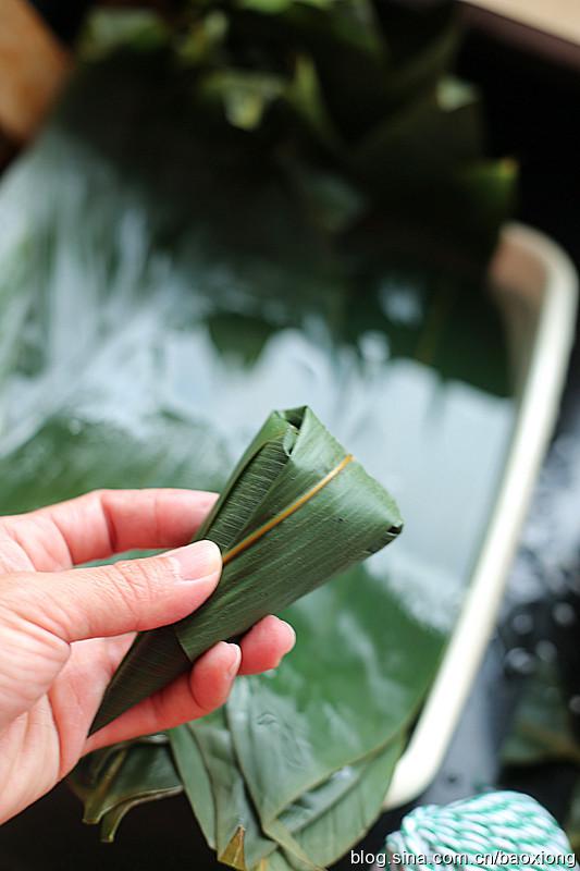 三种粽子包法 <wbr>豆沙 <wbr>红枣甜粽 6、把剩余叶片部分翻折过来包住缺口。
