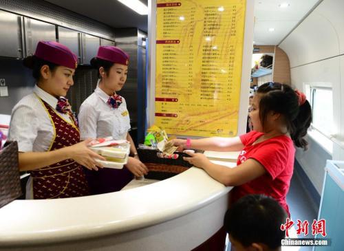 资料图：图为动车组乘务员正在向旅客出售盒饭。胡国林 摄 