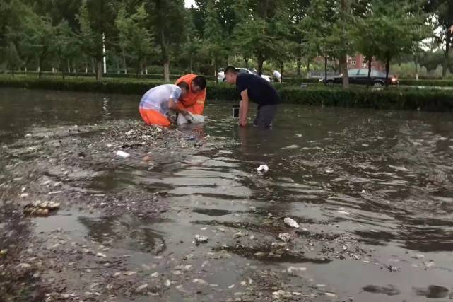 正在冒雨排涝的工作人员 记者 僧少琴 摄