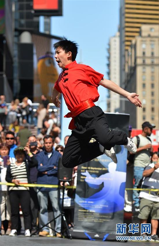 ↑9月10日,在美国纽约时报广场,来自赵长军武术队的队员表演“集体拳”。新华社记者李睿摄
