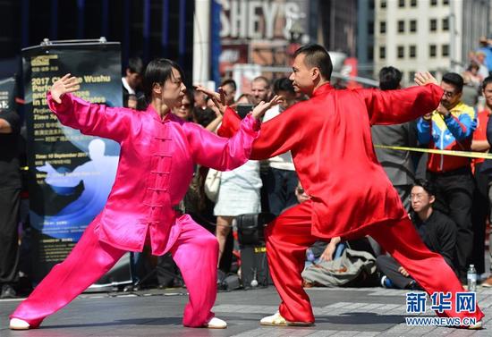 ↑9月10日，在美国纽约时报广场，武术运动员陈思坦（右）和林旭表演“太极对练”。新华社记者李睿摄