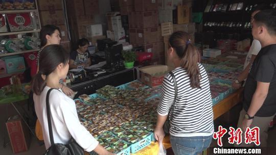 圖為在月餅批發門店，顧客在認真地比對挑選月餅。 李超慶 攝