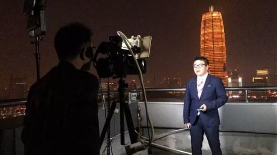 罗煜在郑州电视台顶层进行直播连线