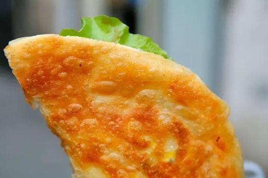 刚出炉的饼刷上秘制的面酱，