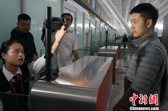图为郑州机场安检工作人员引导乘客正视人脸识别系统摄像头。　韩章云　摄