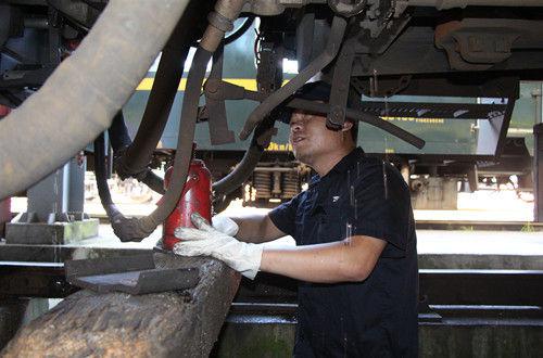  曹忠超在地溝中處理車鉤故障。方昉 攝