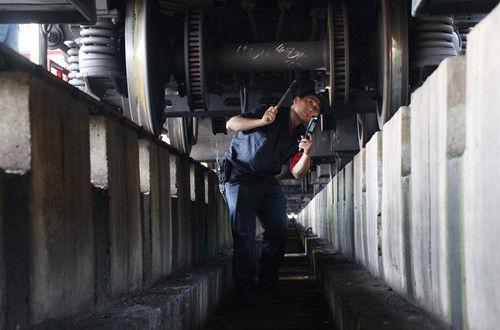  張鑫和同事們在地溝內(nèi)檢查列車。方昉 攝