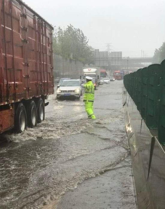 （受台风影响商丘多地区遭遇暴雨，高速交警在商周高速上指挥车辆通行）