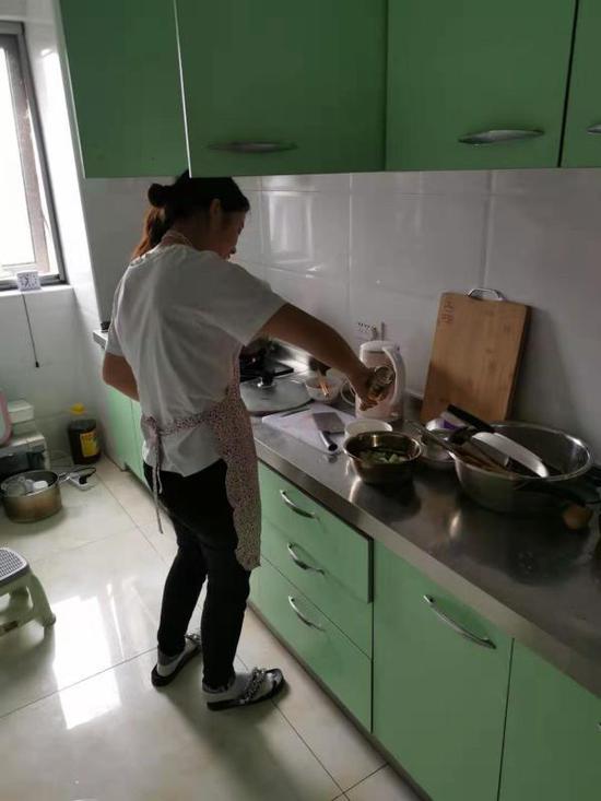 李金鸽在厨房中为丈夫做饭。澎湃新闻记者 戴越 图