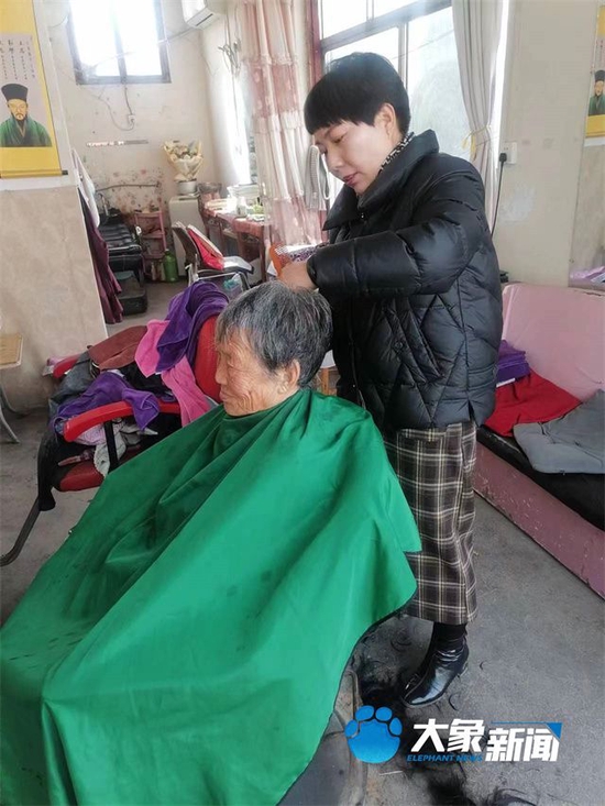 张进巧在理发店为老人理发