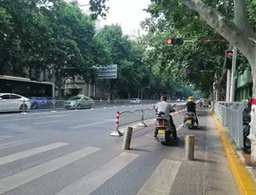 △在郑州市文化路上，隔离桩的设置让非机动车只能从中间部分穿过