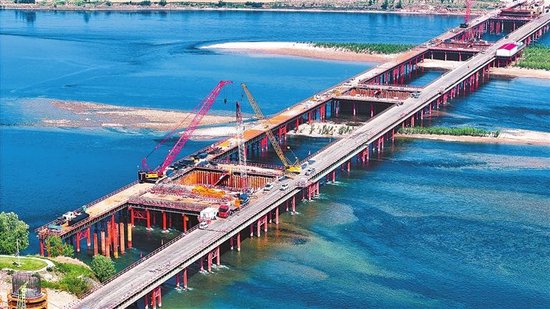 4月18日，洛阳市孟津区焦济洛平高铁洛阳黄河公铁大桥建设现场塔吊林立、机械轰鸣，施工正有序推进。大桥全长13.36公里，为双层结构：上层为208国道，双向八车道公路，设计时速80公里；下层为双线高速铁路，设计时速350公里，是呼南高铁的关键控制性工程。大桥建成后将完善洛阳及沿线城市区域综合交通网络，强化互联互通，助力豫西经济与文旅融合高质量发展。 王宏欣 摄