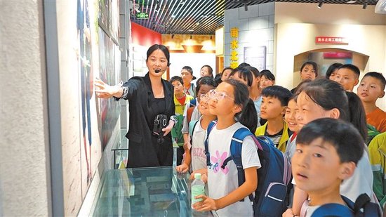 研学小朋友们在淅川丹江移民民俗博物馆中听讲解员讲述移民故事，感受移民精神。