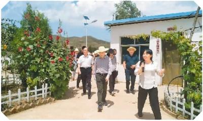 王艳(右)在自家的地达菜加工厂迎接海归服务团的到来