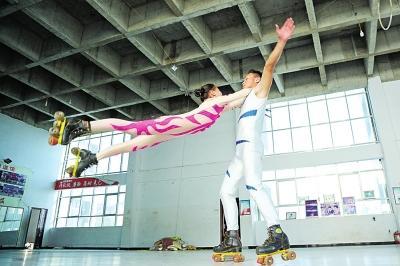 因冰面训练场尚未建成,演员们踩着轮滑鞋进行冰上杂技模拟训练。