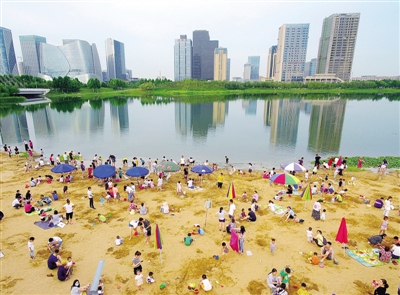 7月5日,郑州市龙子湖边的亲水沙滩上,家长带着孩子们在尽情玩耍,体验海滩的感觉。 郑报全媒体记者 周甬 图