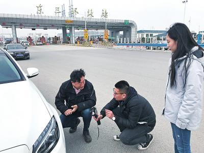 盧寧軍（左）在收費站停下車后給大河報記者分析疑點