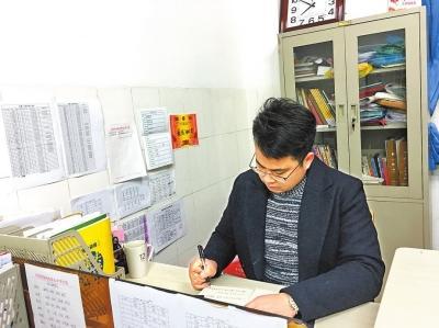 代志豪老師正在為學生們批改作業。本報記者周曉荷攝