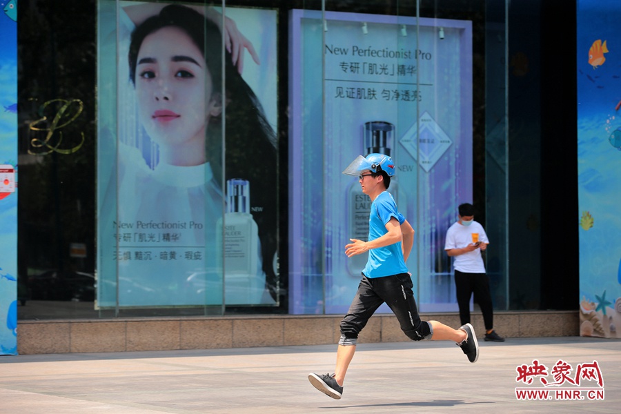 一位外賣小哥在中午的烈日下為了生活奔跑