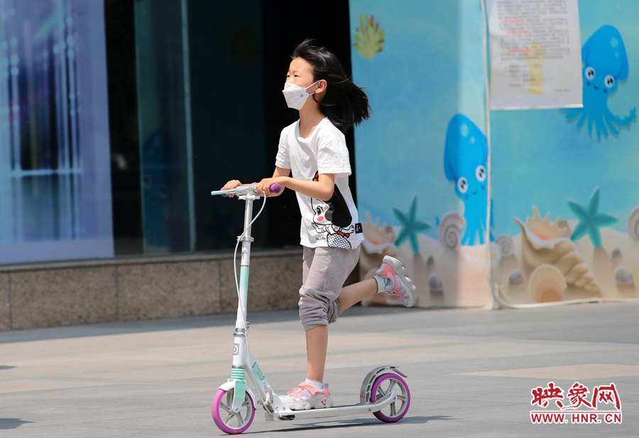 一個(gè)小朋友在陽光下玩滑板