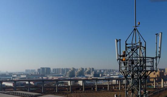 1月17日，牛军辉在郑州东站附近的一座信号塔上进行检修作业（无人机拍摄）。