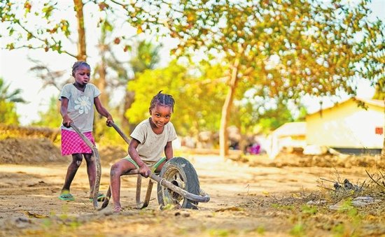 2026年1月18日，几内亚博凯地区，小朋友在当地新建的房子前玩耍，中国企业的到来改善了当地人们的生活。　本报全媒体记者　王亚鸽　崔超　摄