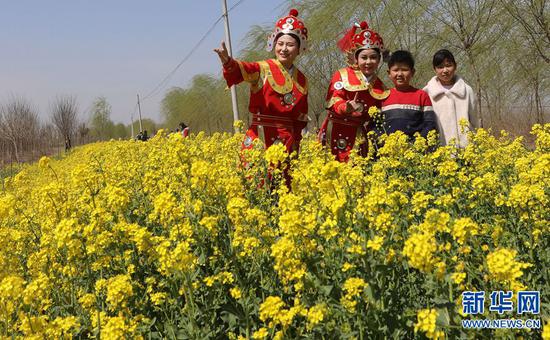 3月23日，河南封丘縣陳橋鎮(zhèn)濕地公園，游客在油菜花海里踏青賞花。