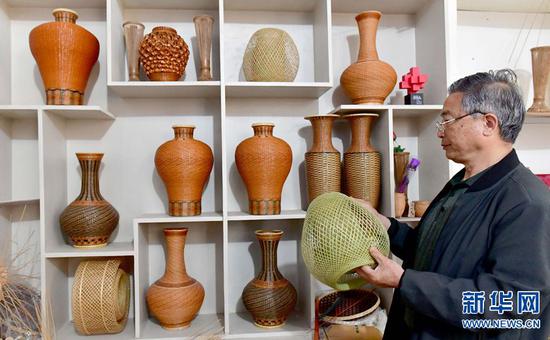 张永杰在展示他的竹编工艺品。