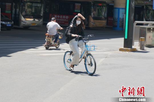 高温下，郑州市民做好防晒措施出行。　韩章云 摄