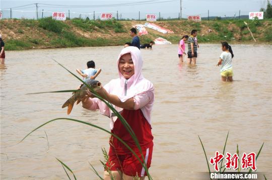 成功摸到大鲤鱼让参与者开心不已 韩章云 摄