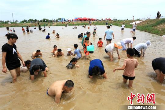 暑期郑州家长带娃“浑水摸鱼”撒欢儿 徐志清 摄