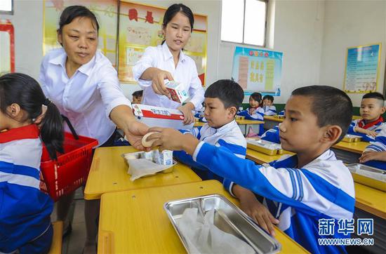河北霸州胜芳镇巨华小学老师在为学生发放“免费课间餐”。新华社记者李晓果摄