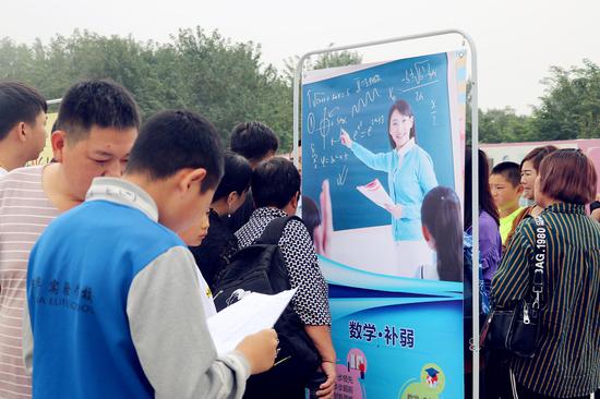 数学补弱课展位前挤满了前来咨询的学生与家长