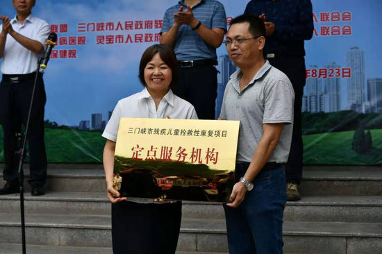 三门峡市残联理事长彭博向灵宝市妇幼保健院授三门峡市残疾儿童抢救性康复项目定点服务机构牌