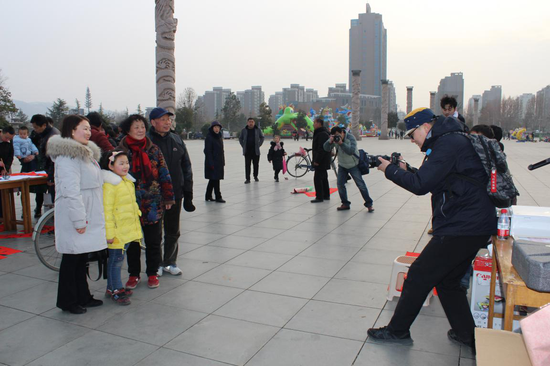河南省文艺志愿者付锐现场为百姓拍摄全家福照片