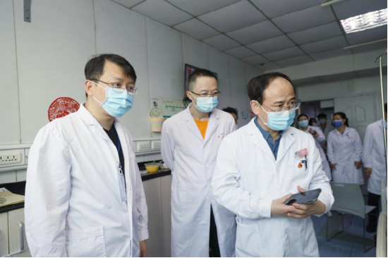 李承浩副教授(左一)、李盛副教授(左二)与李永林主任(右一)进行术前查房并赠送礼物