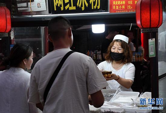6月2日,在河南省开封市鼓楼夜市,食客在购买小吃。